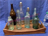 Wooden tray of old advertising bottles