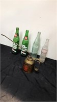 Vintage glass soda pop bottles with oil can
