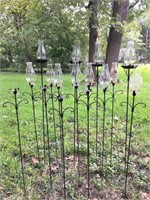 Outdoor iron candleholders with glass chimneys.