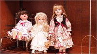 Three dolls: two on stands, one in a brass
