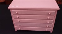 Five-drawer wood jewelry cabinet painted pink,
