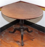 Round tri-foot tilting pedestal table, top is