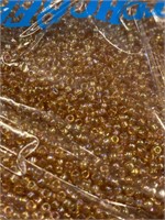Toho 5/0 glass round seed beads. Dark topaz two