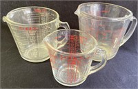 Three Pyrex measuring cups