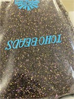 Toho 15/0 hex seed bead. Metallic purple iris.