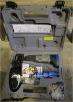 Dremel in box with charger and battery.