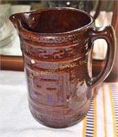 Brown stoneware pitcher, small chip. Height: 8.25"