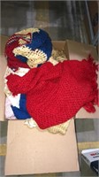 Box of knit shawls, scarves, and hats