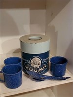 Sugar canister, speckled enamelware cups, spoons