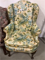 Upholstered wingback chair with lurid upholstery