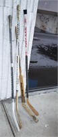 4 used hockey sticks including one goalie stick