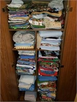 Misc quilted fabric, table cloths (cabinet full)