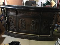 Beautifully carved beverage bar.Dark wood  With