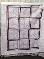 cross stitched quilt in purples