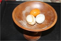 Wooden dish on pedestal and three stone eggs