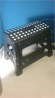 Folding black plastic step stool with white p