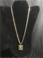 Goldtone necklace with M and a charm