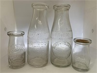 Group of four wide neck milk and cream bottles.