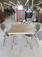 Card table and two metal chairs