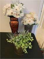 Three containers of artificial flowers.