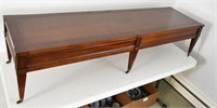 Mahogany six leg cocktail table on rollers,