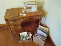Singer sewing machine in cabinet with accessories