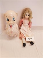 Porcelain doll and plastic pig bank