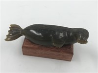 Resin figurine of a seal on a hardwood base about