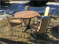 Round table with 4 chairs, one chair has a rip