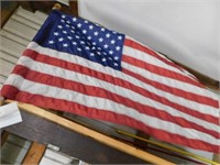 Fifty star nylon American flag on wooden pole,