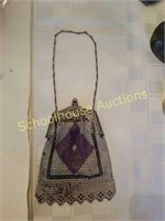 Purple, white, and black purse. Appears to be in