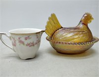 amber coloured glass hen and a tea cup