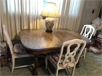 Oak dining room table with four white chairs