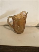 Light brown carnival glass pitcher with windmill