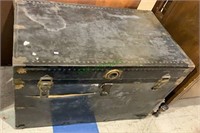 Large antique black metal storage trunk, with the