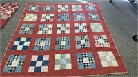 Antique quilt, blue and brown squares on a red