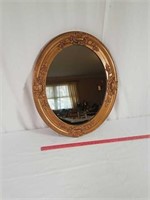 Ornate antique wood oval mirror.