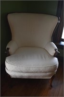 CREAM UPHL. ARM CHAIR W/ CARVED ARMS - CURVED BACK