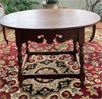 Small oval walnut side table with a fancy carved