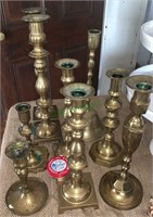 Collection of 9 brass candlesticks with a little
