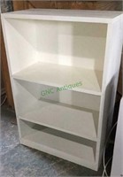 Wooden bookcase/shelf unit. White in color.