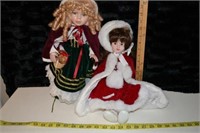 2 xmas porcelain dolls one chip in leg red doll