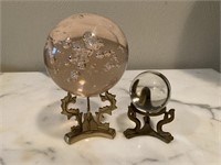 (2) “crystal” balls on brass stands.