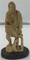 Very old ivory carving of an old man, holding a ba