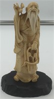 Ivory carving of an old man with a white beard hol