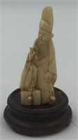 Small ivory carving of a man wearing a tall hat, c