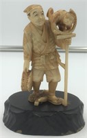 Ivory carving of a man with a monkey on a stand, p