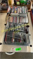 Collection of CDs and racks, video games