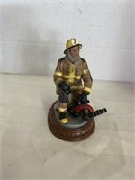 firefighter holding firehose figurine