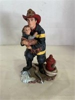fire fighter holding a little boy figurine